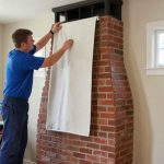 Chimney technician laying down a drop cloth and setting up equipment inside a homeowner's living room before a service visit — Spring Hill Chimney Service NEPA.jpg