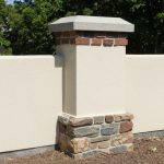 Brick chimney rising from a parged concrete foundation base showing the structural connection point — Spring Hill Chimney Service NEPA