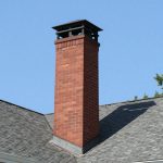Snow-covered brick chimney on a residential roof in northeastern Pennsylvania during a winter storm — Spring Hill Chimney Service NEPA